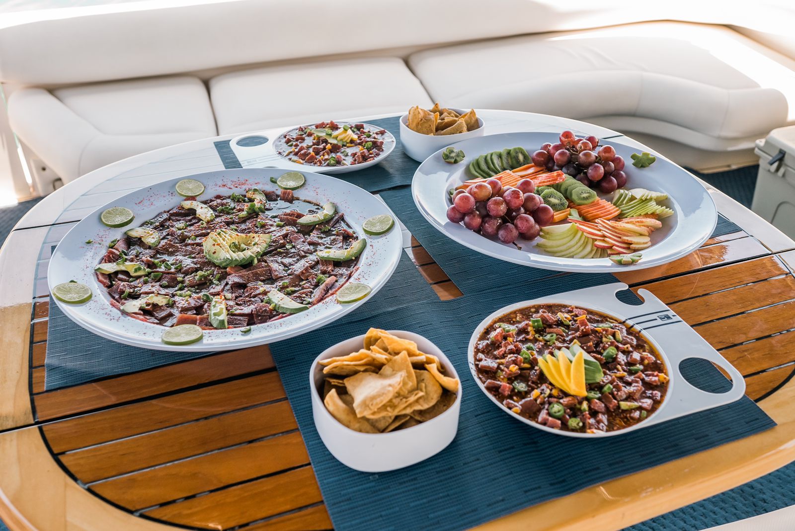 Gourmet seafood platter served on a wooden table on a boat deck at sunset